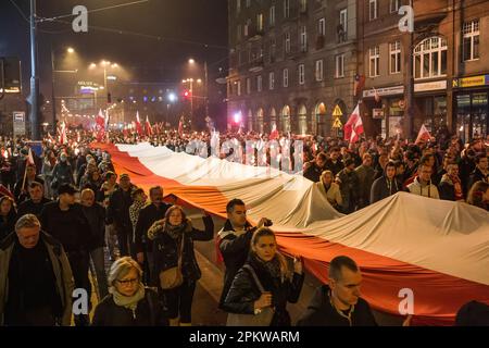 Breslau, Dolnoslaskie, Polen. 11. November 2014. Demonstranten tragen während des Protests eine riesige polnische Nationalflagge. Am 11. November findet der Polnische Unabhängigkeitstag statt, der große Unabhängigkeitsmarsch. Die Demonstranten fordern eine Rückkehr zu den traditionellen polnischen Werten und Identität und berufen sich dabei oft auf Katholizismus und Nationalismus als wichtige Teile ihrer Weltsicht. Viele von ihnen schließen sich rechtsextremen politischen Ideologien an und sind mit Organisationen wie der Nationalen Wiedergeburt Polens und der Allpolnischen Jugend und Fußball-Hooligans verbunden. Es sei jedoch darauf hingewiesen, dass nicht alle Teilnehmer i sind Stockfoto