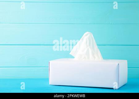 Karton mit Papiertüchern auf blauem Hintergrund. Draufsicht Stockfoto