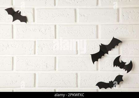 Fliegende schwarze Fledermäuse auf weißem Hintergrund, Halloween-Dekorationskonzept. Stockfoto