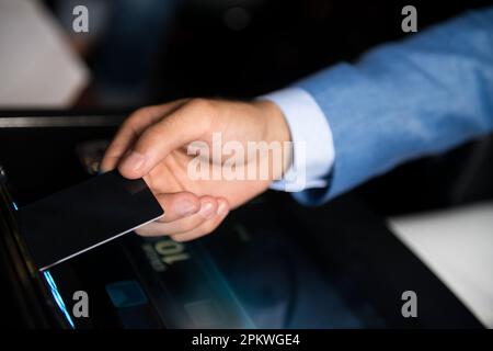 Männlicher Spieler Handheld-Kreditkarte bereit, das Spiel im Casino zu gewinnen, wenn er Slot Machine Closeup spielt Stockfoto