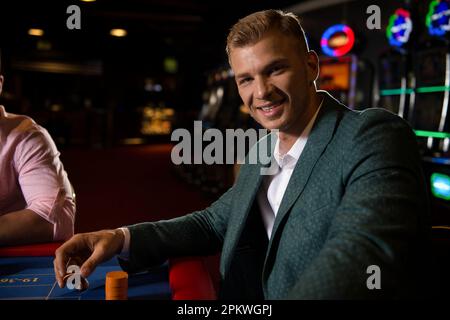 Die Gruppe der jungen Reichen spielt Roulette im Casino Stockfoto