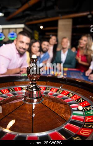 Ein wunderschönes und gut gekleidetes Paar, das Roulette im Casino spielt - flache Feldtiefe Stockfoto