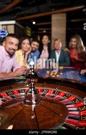 Ein wunderschönes und gut gekleidetes Paar, das Roulette im Casino spielt - flache Feldtiefe Stockfoto