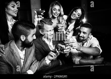 Wunderschönes und gut gekleidetes Paar, das Roulette im Casino spielt und Alkohol trinkt, um zu feiern Stockfoto