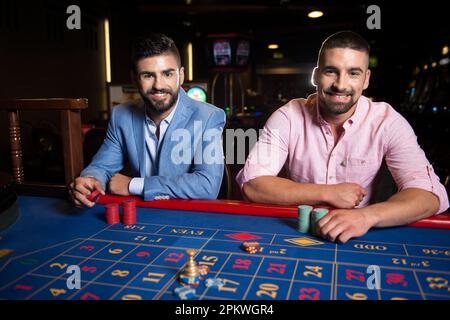 Die Gruppe der jungen Reichen spielt Roulette im Casino Stockfoto