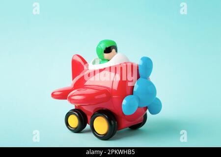 Spielzeugflugzeug aus Kunststoff auf blauem Hintergrund. Draufsicht Stockfoto