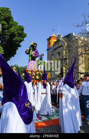 Mexikanische Anhänger mit Kapuze tragen die religiöse Palanquin während der Karfreitagsprozession, in der Heiligen Woche, Oaxaca de Juárez , Mexiko Stockfoto