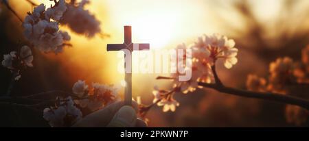 Hintergrund mit rotem Sonnenuntergang und Kirschblüten im Frühling und Christian mit dem Heiligen Kreuz von Jesus Christus Stockfoto