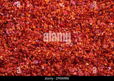 Getrocknete rote Pfefferflocken aus der Nahaufnahme. Gewürze und Kräuter. Hintergrund der samenlosen Chilipfeffer-Flocken. Stockfoto