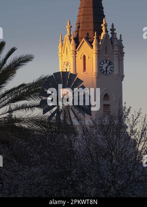 Die Vosburger Holländische Reformkirche mit Windmühle in der untergehenden Sonne. GPS-Position --- 30° 34' 35,76' Süd & 22° 52' 46,08' Ost. Stockfoto