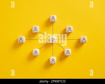 Teamarbeit und kreative Ideenentwicklung. Brainstorming. Kreative Zusammenarbeit in der Wirtschaft. Die Teammitglieder verbinden sich mit dem Idea-Glühbirnensymbol auf Holz Stockfoto
