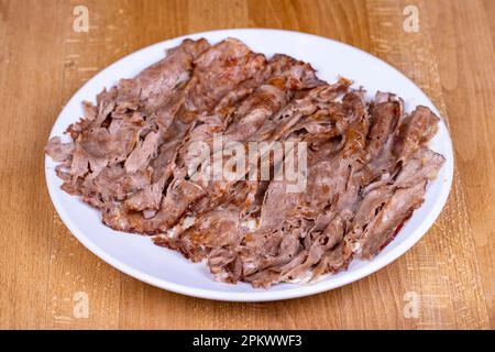 Fleischspender Kebab. Türkischer Döner Kebab auf Holzboden. Türkische Köstlichkeiten. Lebensmitteltourismus. Stockfoto