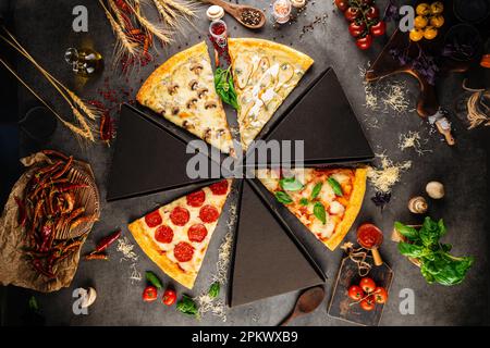 Verschiedene Pizzascheiben mit verschiedenen Belägen Stockfoto