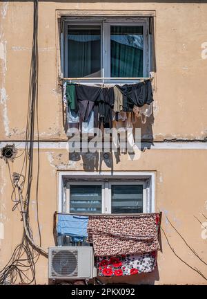 Altes, abgenutztes kommunistisches Wohnhaus in Bukarest, Rumänien. Auf dem Balkon wurde alte Wäsche zum Trocknen zurückgelassen. Stockfoto