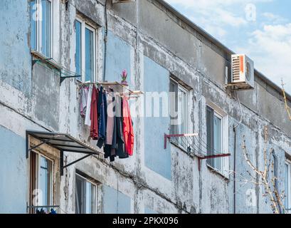 Altes, abgenutztes kommunistisches Wohnhaus in Bukarest, Rumänien. Auf dem Balkon wurde alte Wäsche zum Trocknen zurückgelassen. Stockfoto