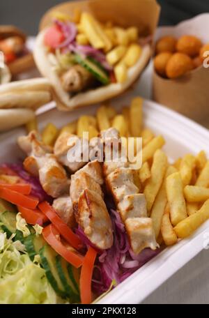 Griechische kalamaki-, Souvlaki- und Gyros-Gerichte werden zum Mittagessen in einem Restaurant zubereitet. Traditionelles mediterranes Fast Food zum Mitnehmen in einem Diner Stockfoto