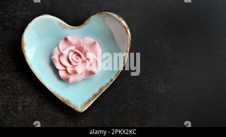 Kokosmilch-Geschmack, traditioneller thailändischer, handgefertigter Snack von Sam Pan Nee auf pastellblauer herzförmiger Platte, dunkler Hintergrund, königlich berühmtes thailändisches Süßigkeiten-Dessert Stockfoto