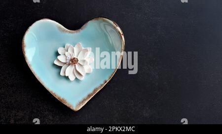 Kokosmilch-Geschmack, traditioneller thailändischer, handgefertigter Snack von Sam Pan Nee auf pastellblauer herzförmiger Platte, dunkler Hintergrund, königlich berühmtes thailändisches Süßigkeiten-Dessert Stockfoto