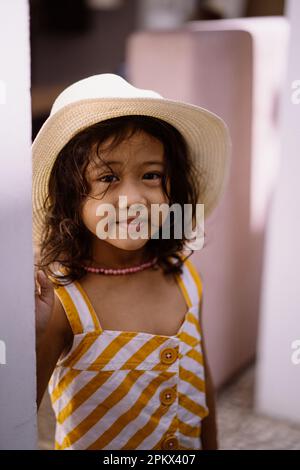 Ein kleines asiatisches Mädchen mit Strohhut Stockfoto