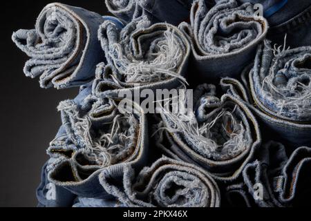 Verblasste blaue Jeans, aufgerollt und organisiert Stockfoto