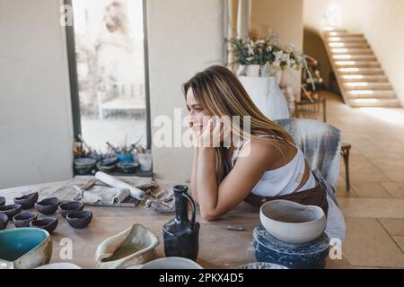 Porträt eines Keramikmädchens, das an einem Tisch sitzt Stockfoto