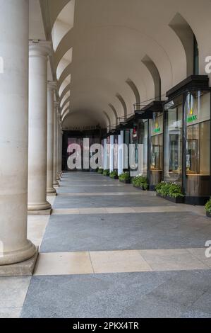 Sehen Sie die Kolonnaden der Geschäfte in der Royal Opera House Arcade auf der Covent Garden Piazza, London, England, Großbritannien Stockfoto