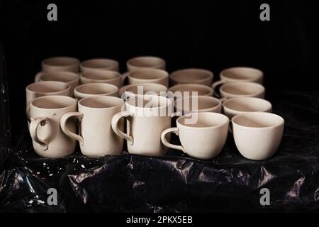 Tonbecher werden getrocknet, bevor sie in der Werkstatt gebacken und lackiert werden Stockfoto