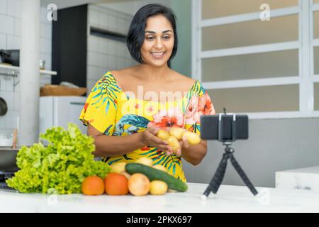 Reifer lateinamerikanischer Food-Blogger, der einen Videoclip in der Küche streamt Stockfoto