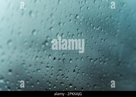 Regenwasser tropft im Hintergrund der Regenzeit auf das Fenster. Depressionen und Traurigkeitsgefühlsbegriff Stockfoto