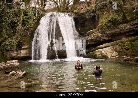 Wilde Schwimmer machen Fotos im kalten Wasser unter dem Janet's Foss Wasserfall, Malham, Yorkshire Dales National Park, Großbritannien Stockfoto