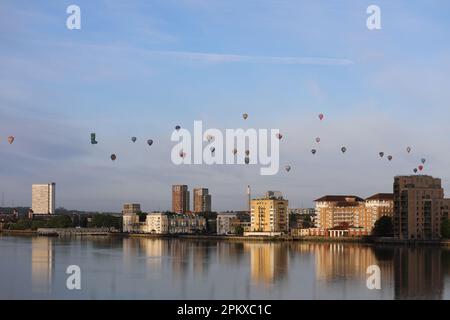 Heißluftballons schweben an der Skyline von Südost-London vorbei und über die Themse als Teil der Ballonregatta des Oberbürgermeisters in den frühen Mornien Stockfoto