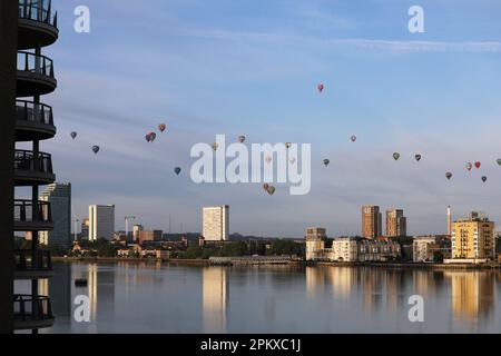 Heißluftballons schweben an der Skyline von Südost-London vorbei und über die Themse als Teil der Ballonregatta des Oberbürgermeisters in den frühen Mornien Stockfoto