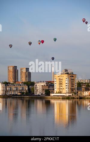 Heißluftballons schweben an der Skyline von Südost-London vorbei und über die Themse als Teil der Ballonregatta des Oberbürgermeisters in den frühen Mornien Stockfoto