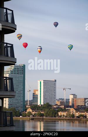 Heißluftballons schweben an der Skyline von Südost-London vorbei und über die Themse als Teil der Ballonregatta des Oberbürgermeisters in den frühen Mornien Stockfoto