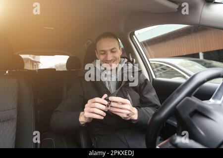 Ein fröhlicher indianer, der Auto fährt, vom Armaturenbrett erschossen wird, während der Sommerferien auf Reisen geht, Kopierraum. Ein glücklicher Typ aus dem Nahen Osten in lässigen Outfits und Stockfoto