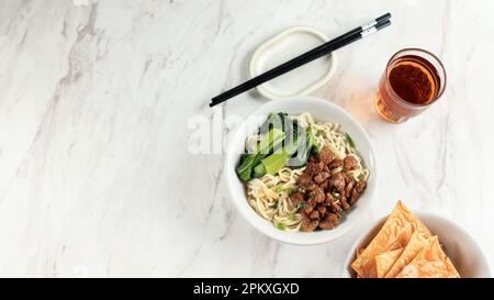 Mie ayam, Mi Ayam oder Bakmi Ayam, beliebtes indonesisches Street Food. Gewürzte gelbe Nudeln serviert mit süßem Soja-Huhn und knusprigen Knödeln. Bereich Kopieren Stockfoto