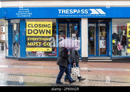 Southend on Sea, Essex, Großbritannien. 10. April 2023. Der Feiertag in Southend auf See hat den ganzen Morgen Regen gesehen. Ein paar Leute sind draußen. Die Sicherheitsmaßnahmen wurden eingerichtet, um eine traditionelle Zusammenkunft von Motorrädern zu verhindern, die den Fischern an der Küste sonst geholfen hätte, Geschäfte zu machen. Leute in der High Street mit Regenschirmen, vorbei an der Schließung des unbefugten Outdoor-Bekleidungsgeschäfts Stockfoto