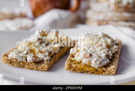 Sandwich mit Hüttenkäse, Honig und Banane auf einem diätetischen Brot. Gesunde Ernährung Stockfoto