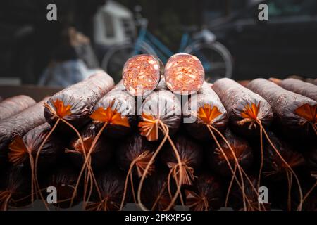 Bild von Kulen Kobasica aus Serbien, geschnitten und stapelt, zum Verkauf bereit. Kulen ist eine traditionelle Art aromatisierter Wurst aus Schweinehackfleisch Stockfoto