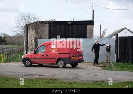 Dorney, Buckinghamshire, Großbritannien. 25. März 2023. Ein Postangestellter von Royal Mail, der Post zu einer Farm in Dorney, Buckinghamshire, bringt. Die Postangestellten befinden sich weiterhin in einem Streit mit der Royal Mail über Bezahlung und Arbeitsbedingungen. Die Mitglieder der CWU, die an der Abstimmung teilgenommen haben, haben für weitere Arbeitskampagnen gestimmt, obwohl noch keine neuen Poststreiktermine angekündigt wurden. Kredit: Maureen McLean/Alamy Stockfoto