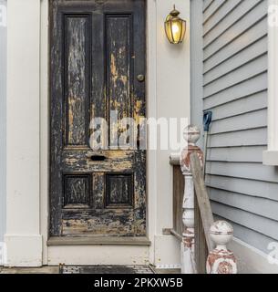 Eine gut abgenutzte schwarze Außentür in Portsmouth Stockfoto