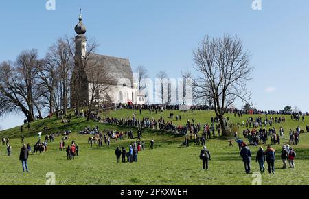 Traunstein, Deutschland. 10. April 2023. Am Ostermontag versammeln sich Menschen vor der Kirche von Ettendorf während der traditionellen Georgi Ride zur Kirche. Kredit: Uwe Lein/dpa/Alamy Live News Stockfoto