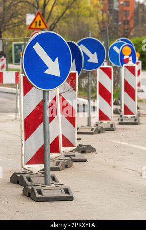 Obligatorische Hinweisschilder für Hindernisumleitung und Sicherheitsschilder auf Straßen, die gewartet und repariert werden, selektiver Fokus Stockfoto