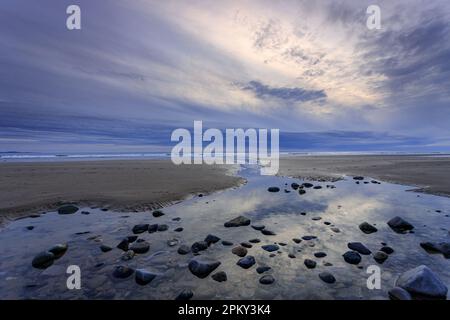 Wolken bei Sonnenuntergang über Dinas Dinlle Beach, Nordwales Stockfoto