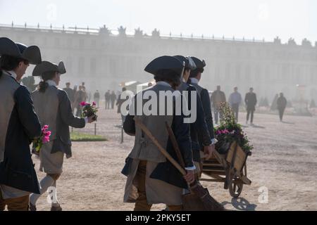 Viktorianisches Zeitalter Frankreich: Männliche Diener in eleganter Kleidung mit Blumen in den Gärten des Schlosses Versailles Stockfoto