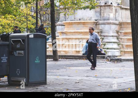 Ein älterer Chinese schlendert durch die bezaubernden Straßen von Paris und bewundert die Sehenswürdigkeiten und Klänge der Stadt der Liebe Stockfoto