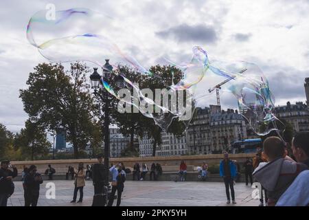 Spektakuläre Seifenblasen-Show: Riesige Blasen inmitten wunderschöner alter Gebäude in Paris Stockfoto