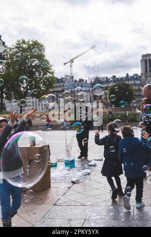 Fröhliche Momente: Kinder genießen eine Seifenblasenparty in Paris Stockfoto