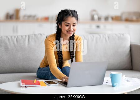 Online-Schulung. Happy Young Indian Female Study Mit Laptop Zu Hause Stockfoto