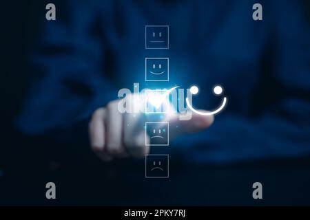 Nahaufnahme eines Kunden, der auf dem virtuellen Bildschirm ein Smiley-Gesicht-Emoticon drückt Stockfoto